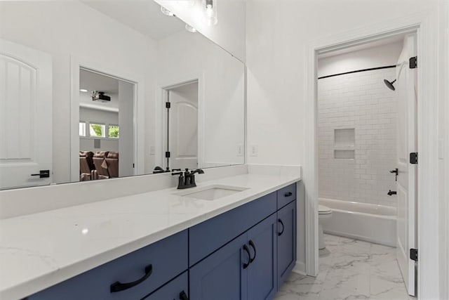 full bathroom featuring tiled shower / bath, vanity, and toilet