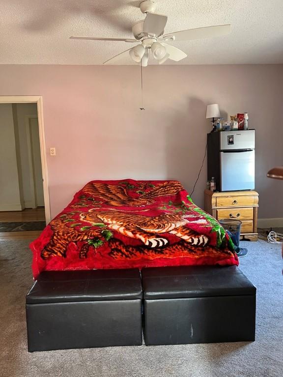 bedroom featuring ceiling fan, carpet, and a textured ceiling