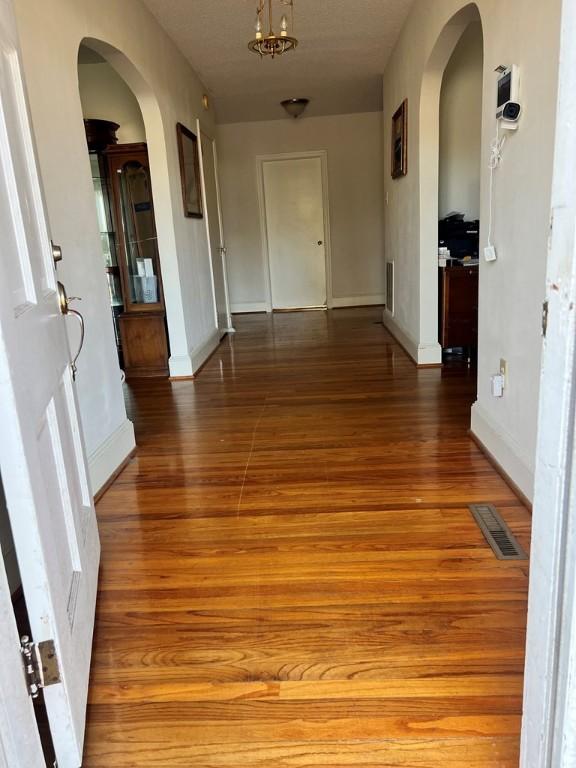 corridor with hardwood / wood-style flooring