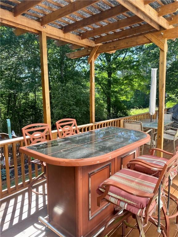 wooden terrace with a bar and a pergola