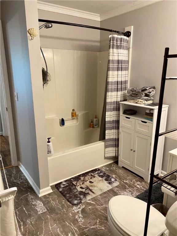 bathroom with ornamental molding, shower / bathtub combination with curtain, and toilet