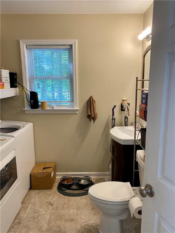 bathroom featuring vanity, toilet, and washer and dryer