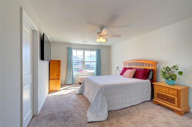 bedroom with ceiling fan and light carpet