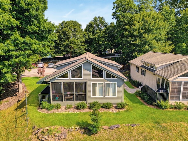 back of house with a yard and a sunroom