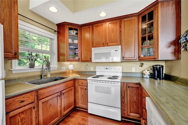 kitchen with sink, white appliances, and light hardwood / wood-style floors