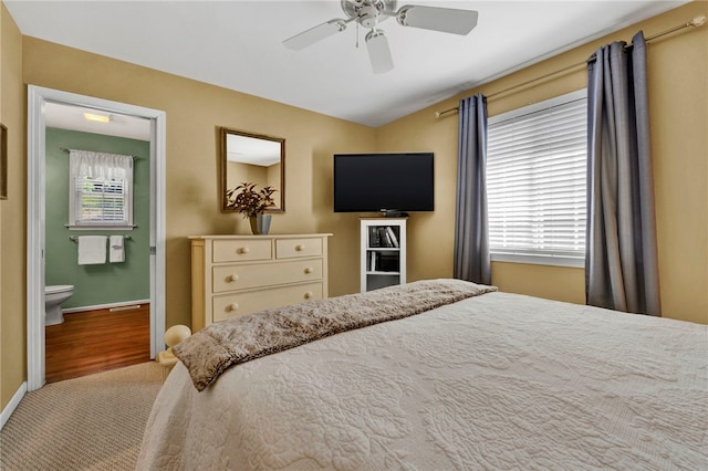 carpeted bedroom with connected bathroom and ceiling fan