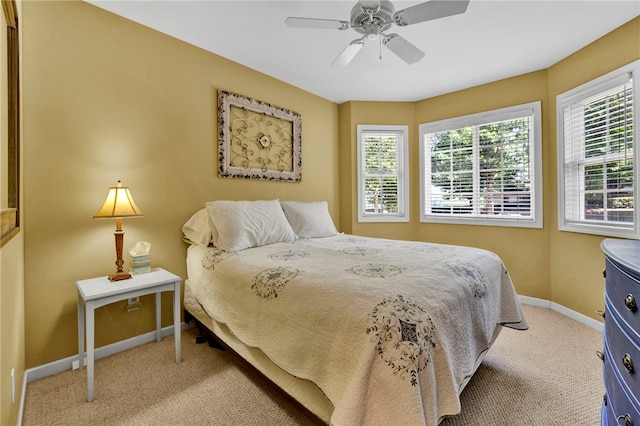 carpeted bedroom featuring multiple windows and ceiling fan