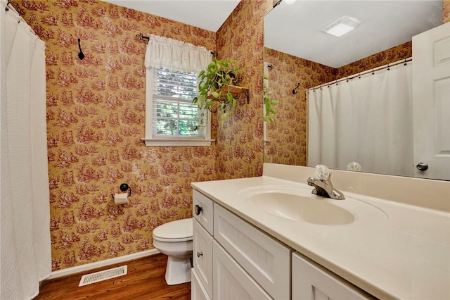 bathroom with vanity, toilet, and hardwood / wood-style floors