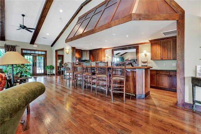 kitchen with ceiling fan, wood-type flooring, high vaulted ceiling, and beamed ceiling