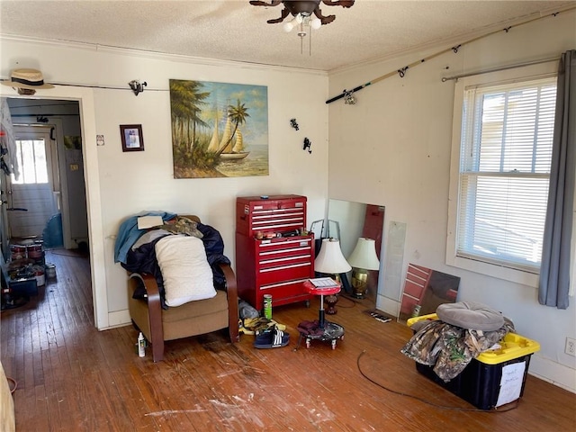 living area with hardwood / wood-style flooring, a wealth of natural light, and a textured ceiling