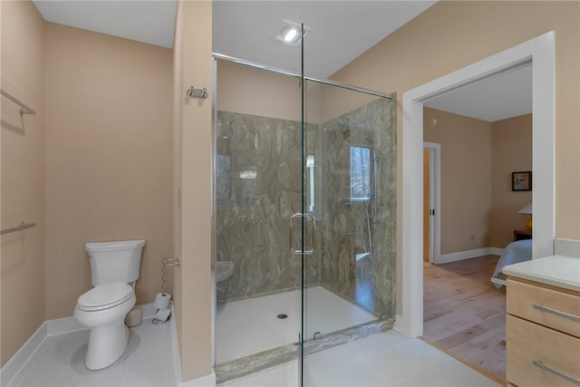 bathroom featuring tile patterned floors, vanity, toilet, and a shower with shower door