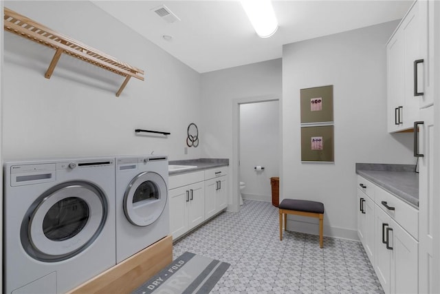 washroom featuring cabinets, separate washer and dryer, and sink