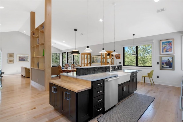 kitchen featuring hanging light fixtures, dishwasher, sink, and a center island with sink