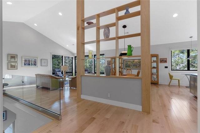 kitchen with high vaulted ceiling and light wood-type flooring