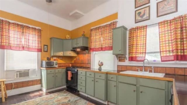 kitchen featuring sink, range with gas stovetop, and green cabinetry