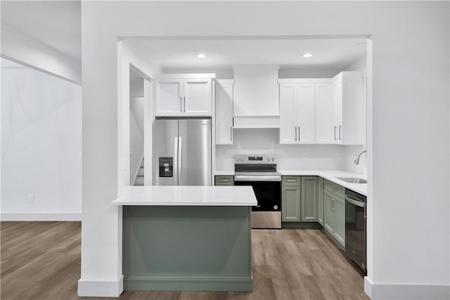 kitchen with green cabinets, appliances with stainless steel finishes, sink, and white cabinets