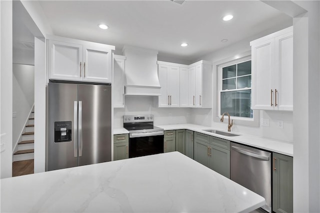 kitchen with sink, white cabinets, custom exhaust hood, stainless steel appliances, and light stone countertops