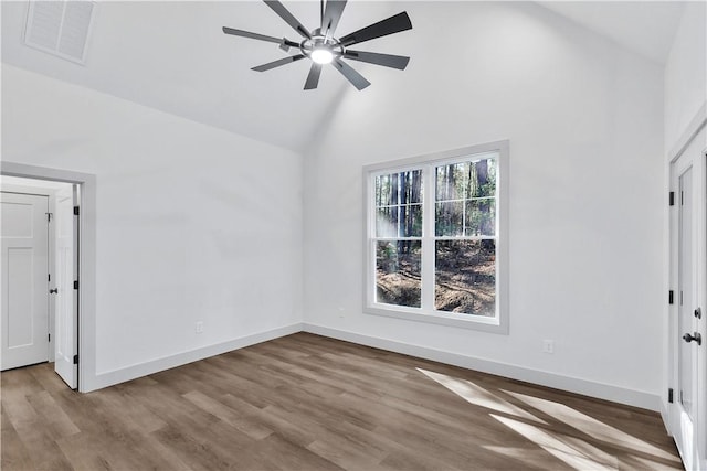 empty room with hardwood / wood-style flooring, ceiling fan, and high vaulted ceiling