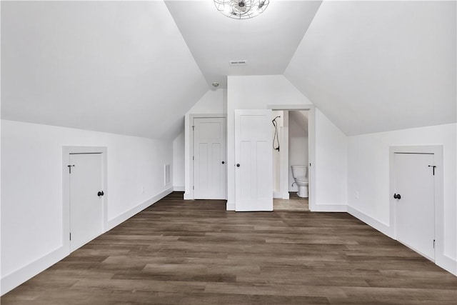 bonus room with lofted ceiling and dark hardwood / wood-style flooring