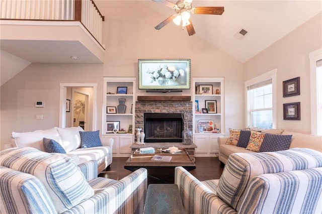 living room featuring a stone fireplace, ceiling fan, high vaulted ceiling, dark hardwood / wood-style flooring, and built in shelves