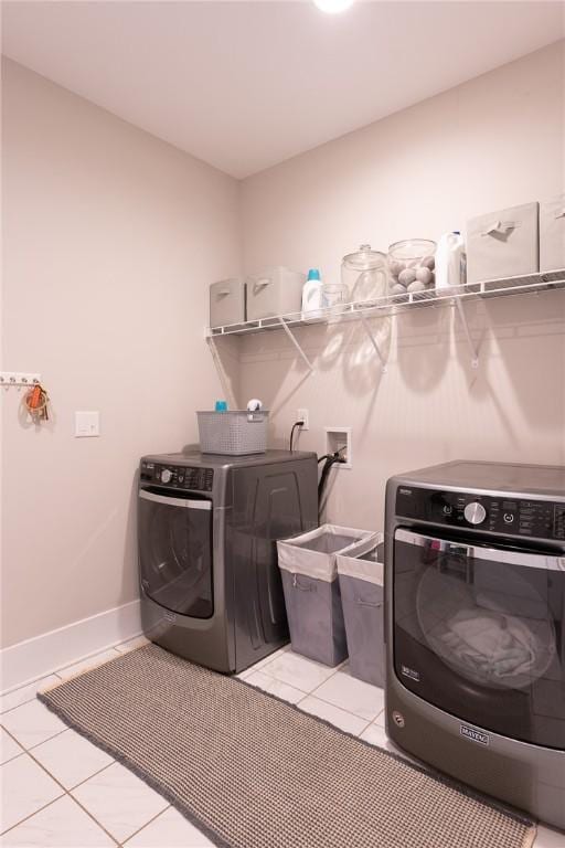 washroom with washing machine and dryer and light tile patterned floors