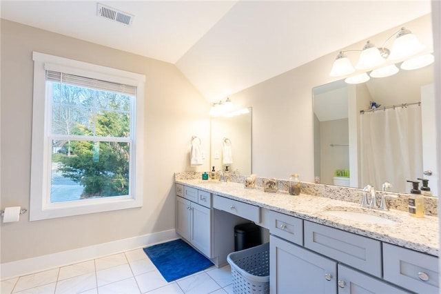 bathroom with vanity, vaulted ceiling, and tile patterned floors