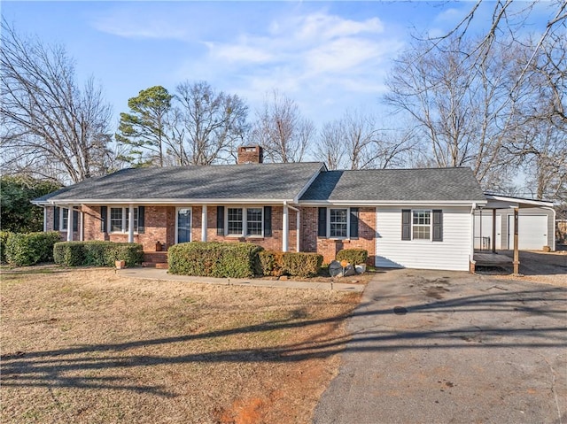 ranch-style house with a carport, a garage, and a front lawn