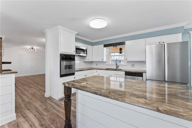 kitchen featuring white cabinetry, stainless steel appliances, sink, and dark stone countertops