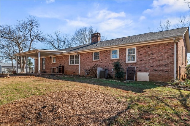 rear view of house with a yard and central AC