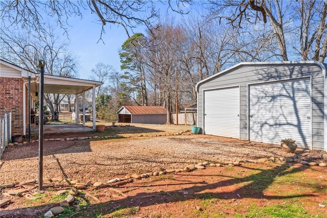 view of yard with a garage and an outbuilding