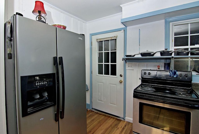 kitchen featuring hardwood / wood-style flooring, ornamental molding, and appliances with stainless steel finishes