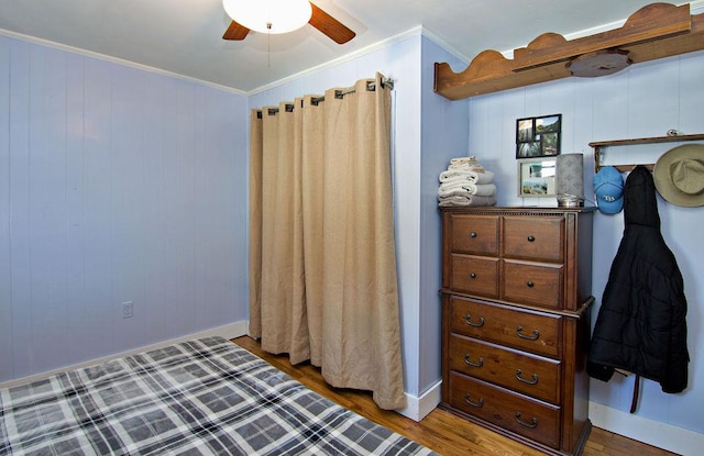 bedroom featuring hardwood / wood-style flooring, ornamental molding, and ceiling fan