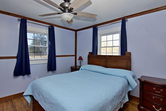 bedroom featuring dark wood-type flooring, ceiling fan, and multiple windows