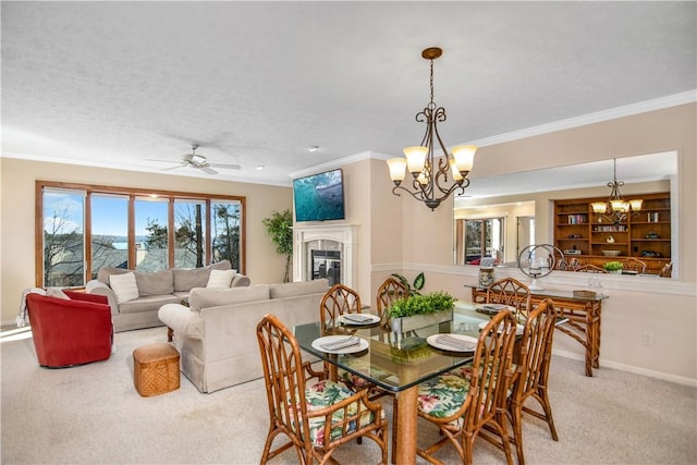 carpeted dining space featuring a tiled fireplace, crown molding, ceiling fan with notable chandelier, and a textured ceiling