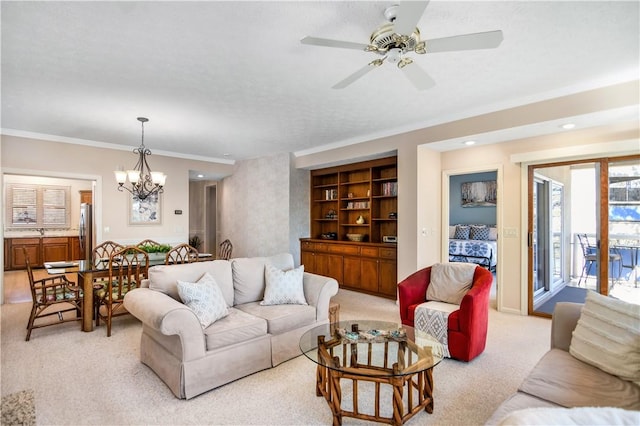 living room with sink, built in features, ornamental molding, ceiling fan with notable chandelier, and light colored carpet