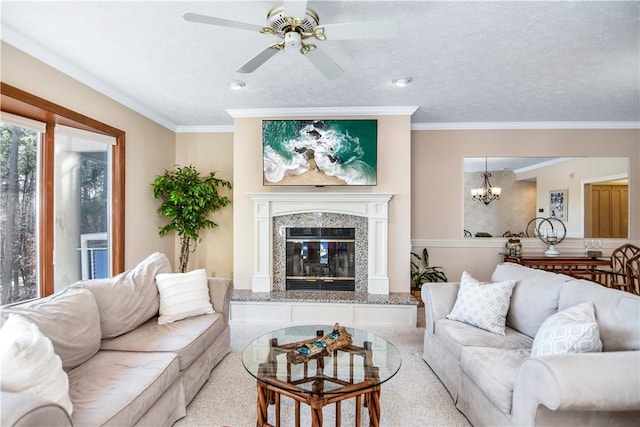 living room featuring crown molding, a fireplace, ceiling fan with notable chandelier, and a textured ceiling