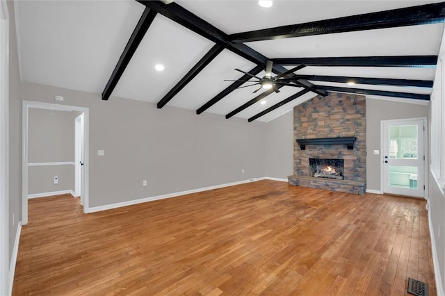 unfurnished living room with vaulted ceiling with beams, a fireplace, ceiling fan, and light hardwood / wood-style flooring