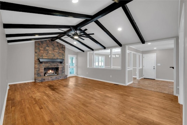 unfurnished living room featuring a stone fireplace, vaulted ceiling with beams, ceiling fan, and light wood-type flooring