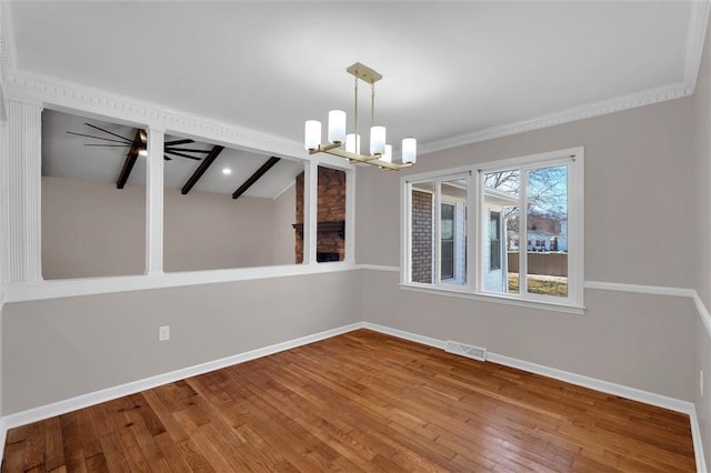 unfurnished dining area with hardwood / wood-style flooring, ornamental molding, and ceiling fan with notable chandelier