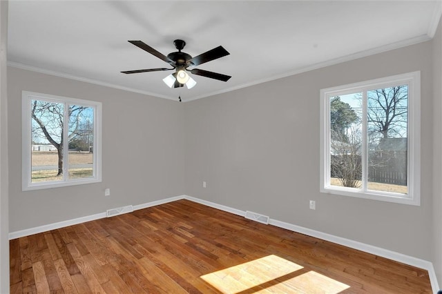 unfurnished room featuring crown molding, ceiling fan, wood-type flooring, and a wealth of natural light