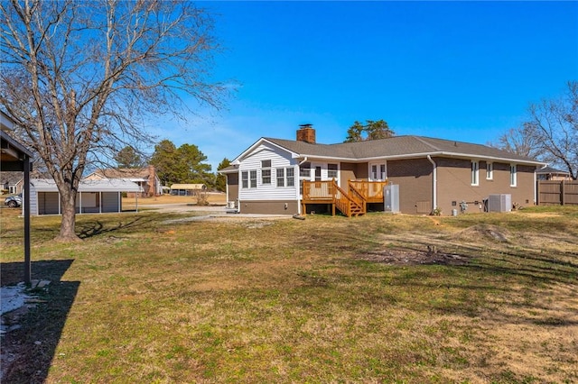 back of property with a deck, a lawn, and central air condition unit