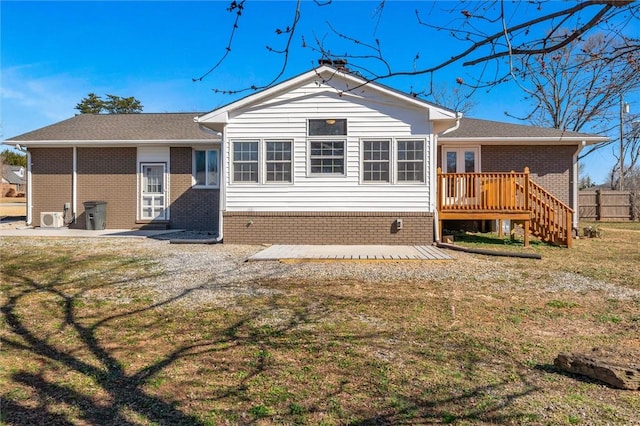 rear view of property with a deck, a patio area, and a lawn