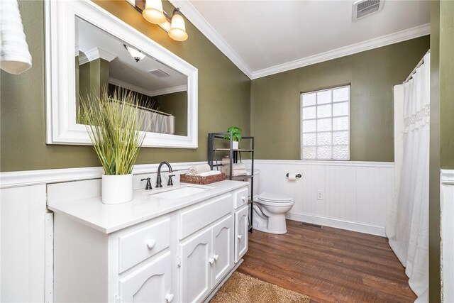 bathroom with hardwood / wood-style flooring, ornamental molding, vanity, and toilet