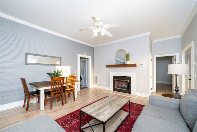 living room with crown molding, ceiling fan, and wood-type flooring