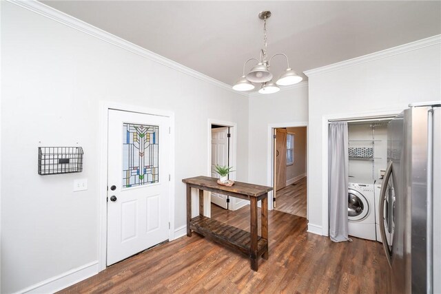 entrance foyer featuring ornamental molding, dark hardwood / wood-style floors, separate washer and dryer, and a notable chandelier