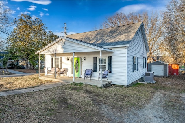 view of front of home with a storage shed, central AC unit, a patio area, and a porch