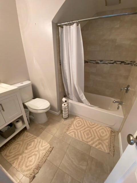 full bathroom with tile patterned flooring, toilet, vanity, and shower / bath combo with shower curtain