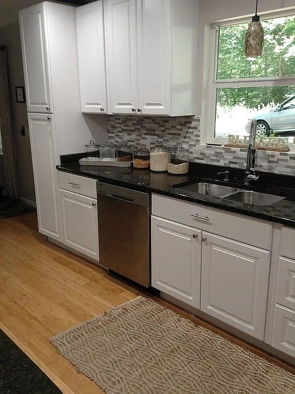 kitchen with white cabinetry, sink, pendant lighting, and dishwasher