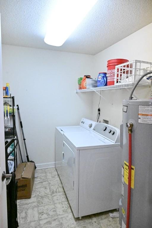 laundry area with a textured ceiling, water heater, and washing machine and clothes dryer