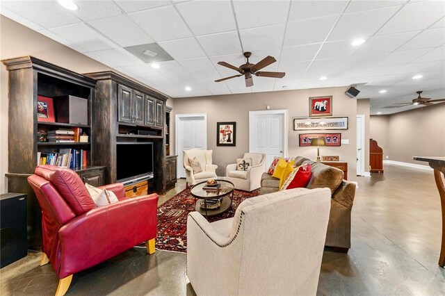 living room with a paneled ceiling and ceiling fan